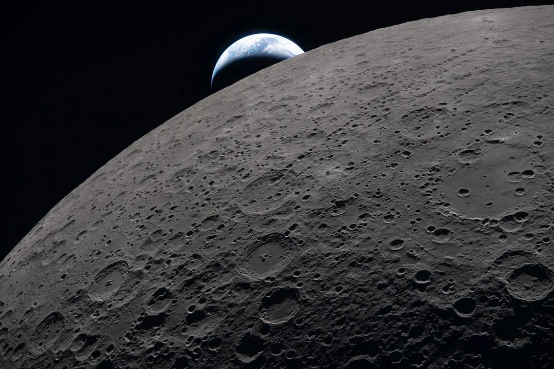 Close-up image of the Moon with the Earth in the background.
